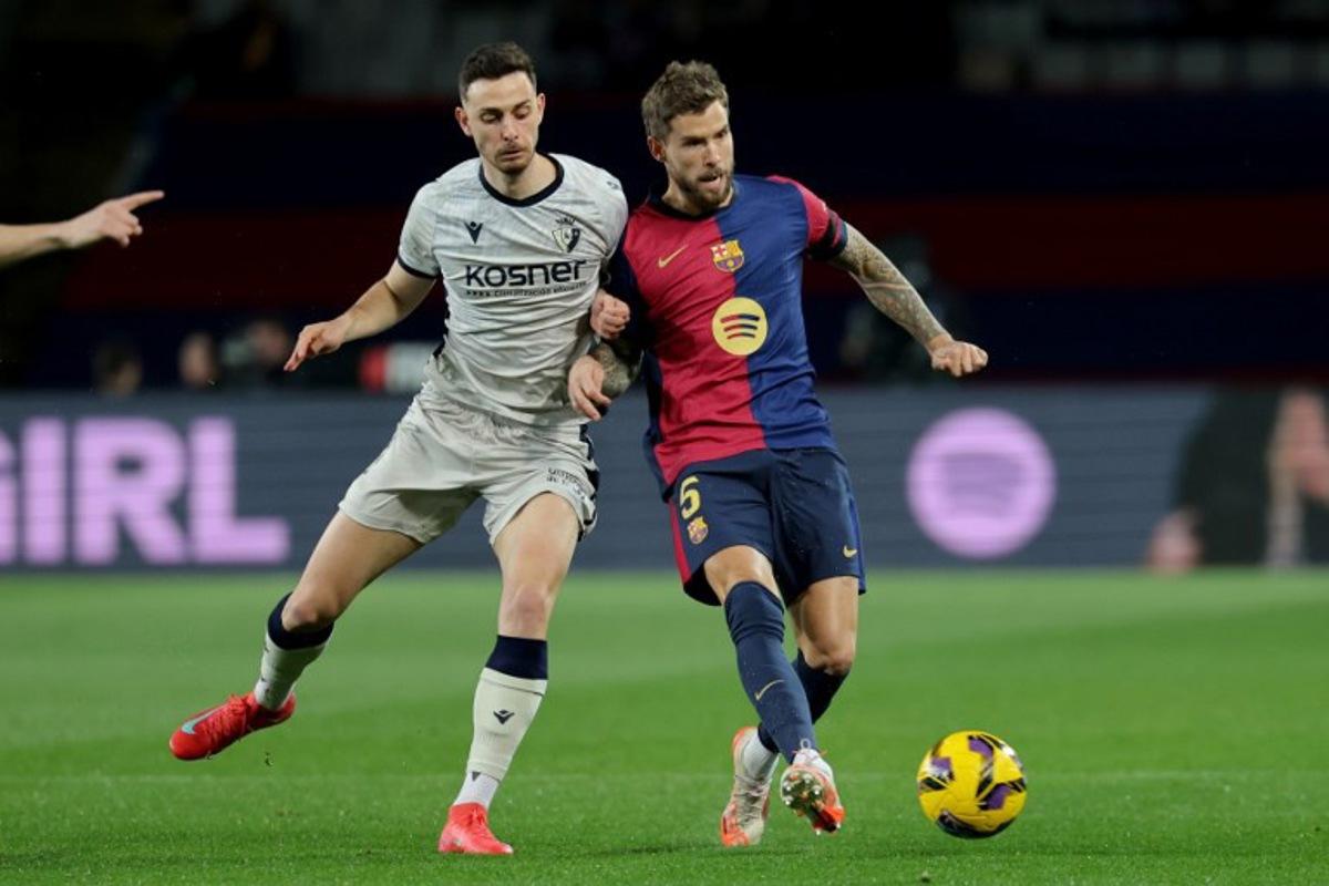 Osasuna's Spanish forward #09 Raul Garcia and Barcelona's Spanish defender #05 Inigo Martinez Berridi fight for the ball during the Spanish league football match between FC Barcelona and CA Osasuna at Estadi Olimpic Lluis Companys in Barcelona on March 27, 2025.  LLUIS GENE / AFP