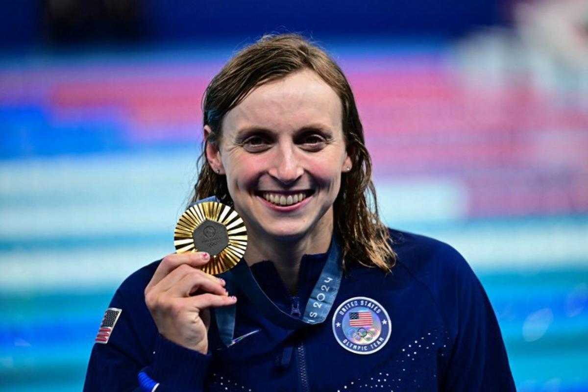 Gold medallist US' Katie Ledecky celebrates during the podium ceremony of the women's 800m freestyle swimming event during the Paris 2024 Olympic Games at the Paris La Defense Arena in Nanterre, west of Paris, on August 3, 2024.  Manan VATSYAYANA / AFP