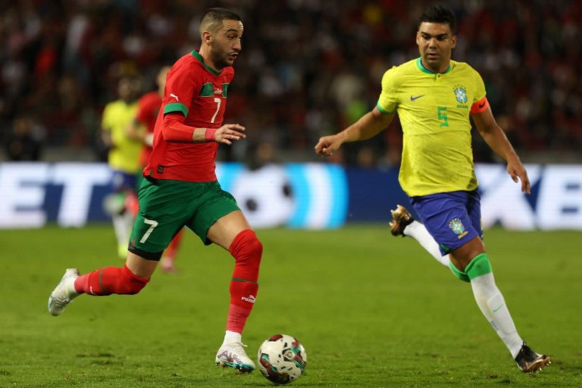 Morocco's midfielder Hakim Ziyech is marked by Brazil's midfielder Casemiro (R) during a friendly football match between Morocco and Brazil at the Ibn Batouta Stadium in Tangier on March 26, 2023.  Fadel Senna / AFP