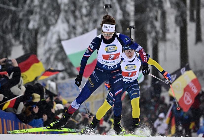 France's Lou Jeanmonnot (L) and Sweden's Anna Magnusson  compete during the women's 4x6km relay event of the IBU Biathlon World Cup in Oberhof, eastern Germany on January 10, 2026.  Tobias SCHWARZ / AFP