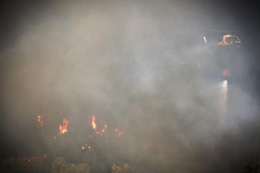 A firefighter helicopter drops water as a wildfire burns in Gondomar, northern Portugal on July 29, 2025. Almost 2,000 firefighters battled on July 29, 2025 to contain forest blazes across Portugal that have led to almost the whole country being put on high alert for fires. Ten major fires blazed with two in the north and three in the centre of the country causing most concern.  CARLOS COSTA / AFP
