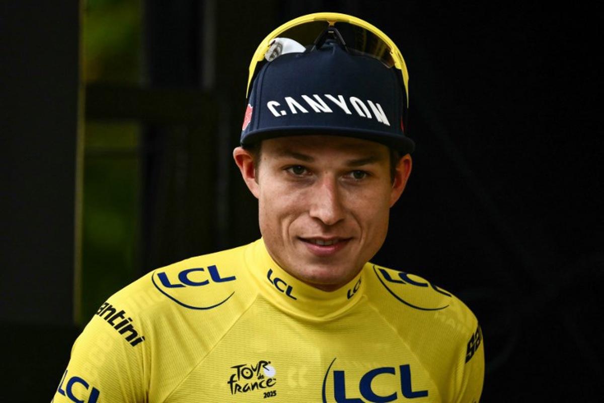 Alpecin - Deceuninck team's Belgian rider Jasper Philipsen celebrates on the podium with the overall leader's yellow jersey after the 1st stage of the 112th edition of the Tour de France cycling race, 184.9 km starting and finishing in Lille Metropole, northern France, on July 5, 2025.  Marco BERTORELLO / AFP