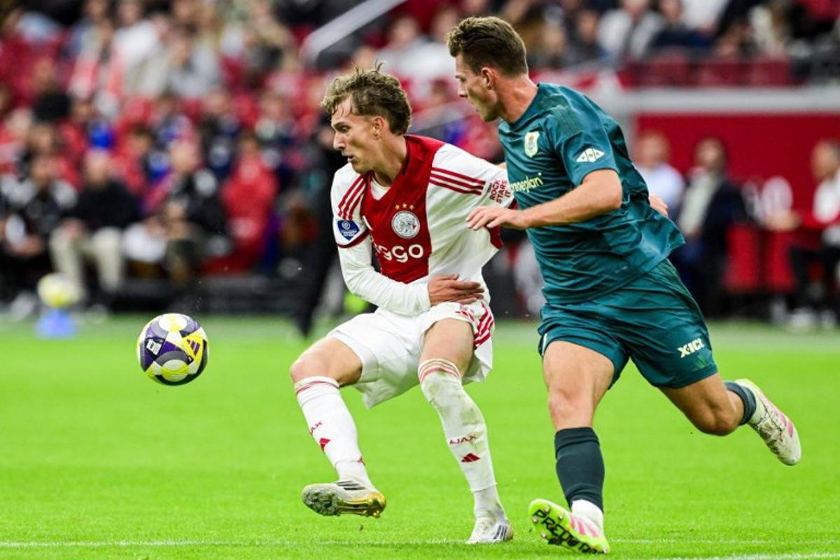 Ajax's Belgian forward #11 Mika Godts (L) fights for the ball with PEC Zwolle's Dutch defender #03 Olivier Aertssen during the Dutch Eredivisie football match between Ajax Amsterdam and and PEC Zwolle at the Johan Cruijff ArenA in Amsterdam on September 13, 2025.  Olaf Kraak / ANP / AFP