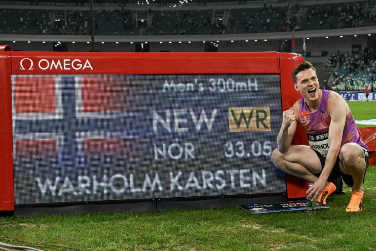 Norway's Karsten Warholm poses with his time of 33.05 seconds after he broke the men's 300m hurdles world record during the Xiamen IAAF Diamond League athletics meeting at Egret Stadium in Xiamen, in China's eastern Fujian province, on April 26, 2025.  ADEK BERRY / AFP