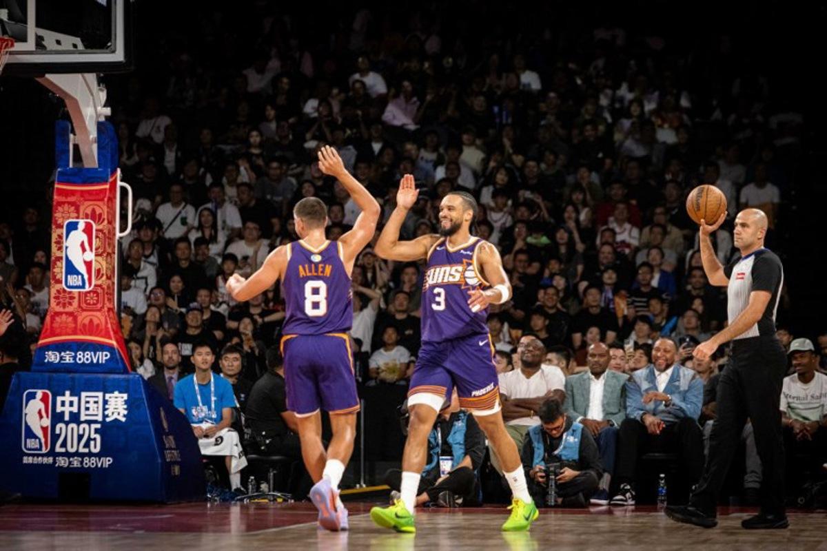 Phoenix Suns' Dillon Brooks (C) high-fives Grayson Allen (L) after scoring two points during the NBA pre-season basketball game between the Phoenix Suns and the Brooklyn Nets at the Venetian Arena in Macau on October 12, 2025. The NBA brought star-studded lineups to Macau this week for the league's return to China after six years, but many of the biggest wins happened off the basketball court, industry insiders and experts told AFP. Eduardo LEAL / AFP