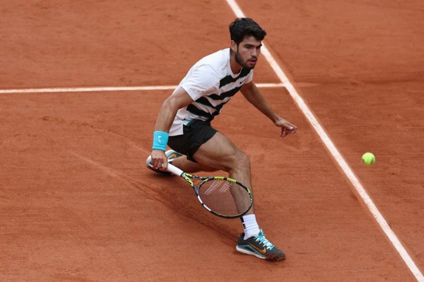 Spain's Carlos Alcaraz plays a backhand return to Italy's Giulio Zeppieri during their men's singles match on day 2 of the French Open tennis tournament on Court Suzanne-Lenglen at the Roland-Garros Complex in Paris on May 26, 2025.  Franck FIFE / AFP