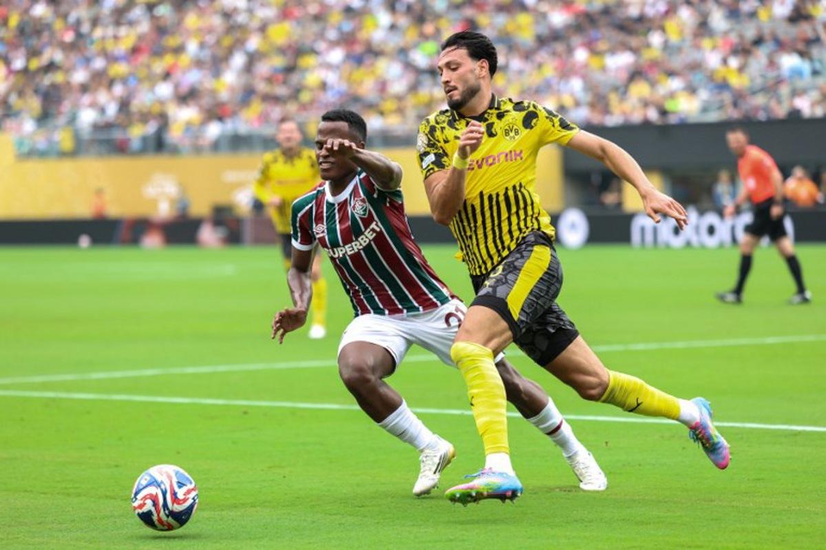 Fluminense's Colombian midfielder #21 Jhon Arias and Borussia Dortmund's Algerian defender #05 Ramy Bensebaini vie for the ball during the FIFA Club World Cup 2025 Group F football match between Brazil's Fluminense and Germany's Borussia Dortmund at the MetLife stadium in East Rutherford, New Jersey on June 17, 2025.  CHARLY TRIBALLEAU / AFP