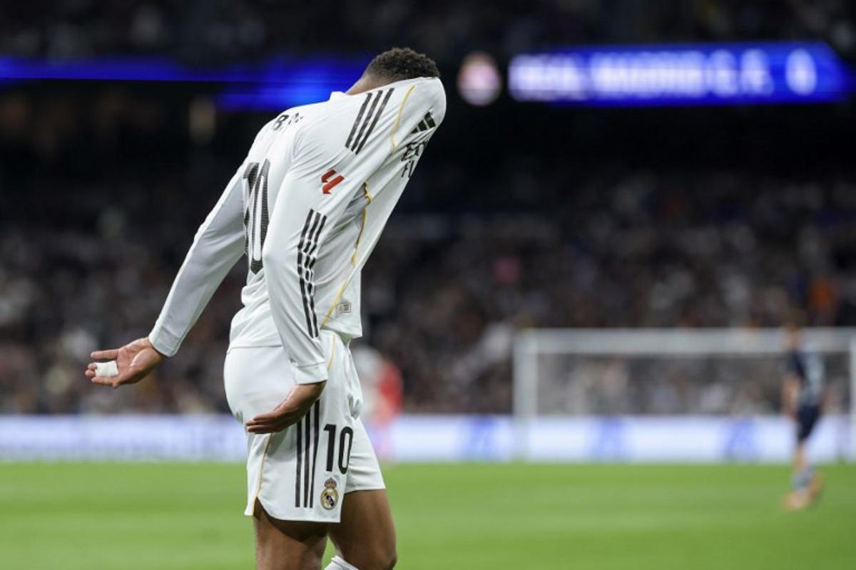 Real Madrid's French forward #10 Kylian Mbappe reacts with his head in his jersey during the Spanish league football match between Real Madrid CF and RC Celta de Vigo at the Santiago Bernabeu Stadium in Madrid on December 7, 2025.  Thomas COEX / AFP