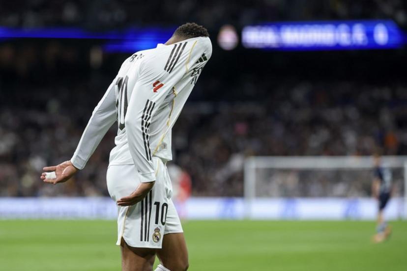 Real Madrid's French forward #10 Kylian Mbappe reacts with his head in his jersey during the Spanish league football match between Real Madrid CF and RC Celta de Vigo at the Santiago Bernabeu Stadium in Madrid on December 7, 2025.  Thomas COEX / AFP