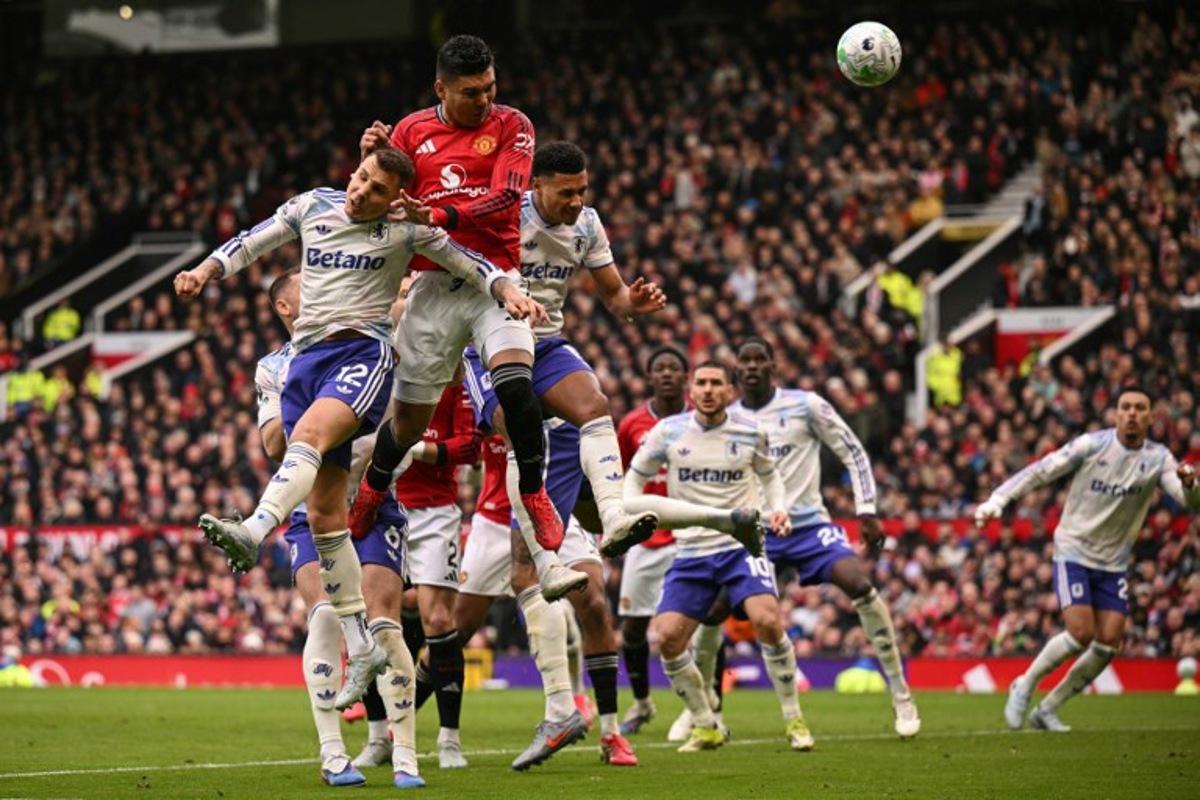 Manchester United's Brazilian midfielder #18 Casemiro (2nd L) heads the ball to score the team's first goal during the English Premier League football match between Manchester United and Aston Villa at Old Trafford in Manchester, north west England, on March 15, 2026.  Oli SCARFF / AFP