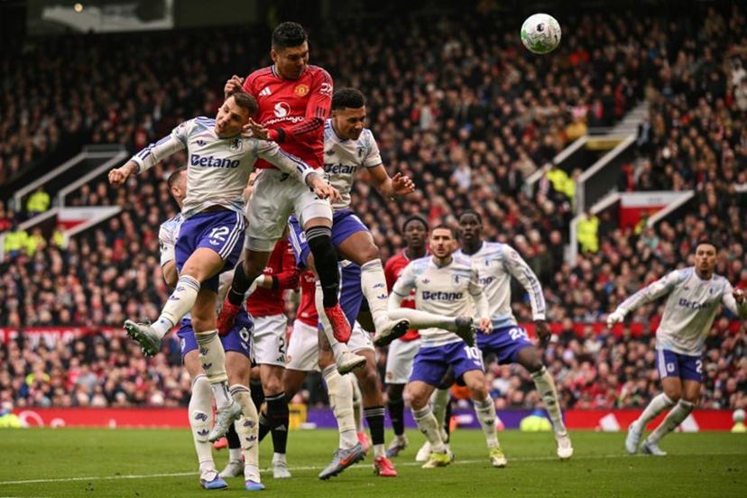 Manchester United's Brazilian midfielder #18 Casemiro (2nd L) heads the ball to score the team's first goal during the English Premier League football match between Manchester United and Aston Villa at Old Trafford in Manchester, north west England, on March 15, 2026.  Oli SCARFF / AFP