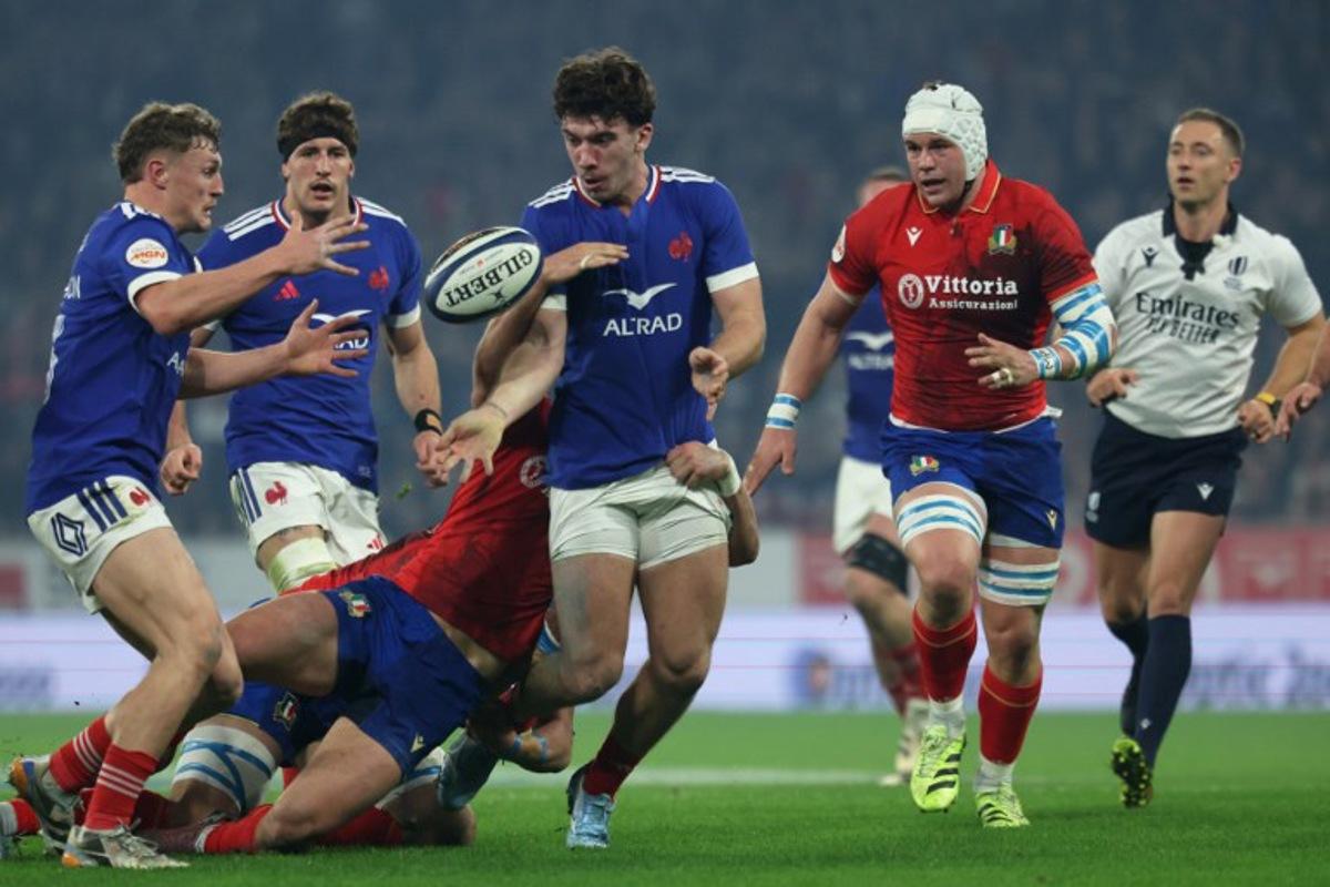 France's centre Fabien Brau-Boirie (C) makes an offload pass to France's centre Emilien Gailleton (L) during the Six Nations international rugby union match between France and Italy at the Stade Pierre-Mauroy in Villeneuve-d'Ascq, northern France, on February 22, 2026.  Francois LO PRESTI / AFP