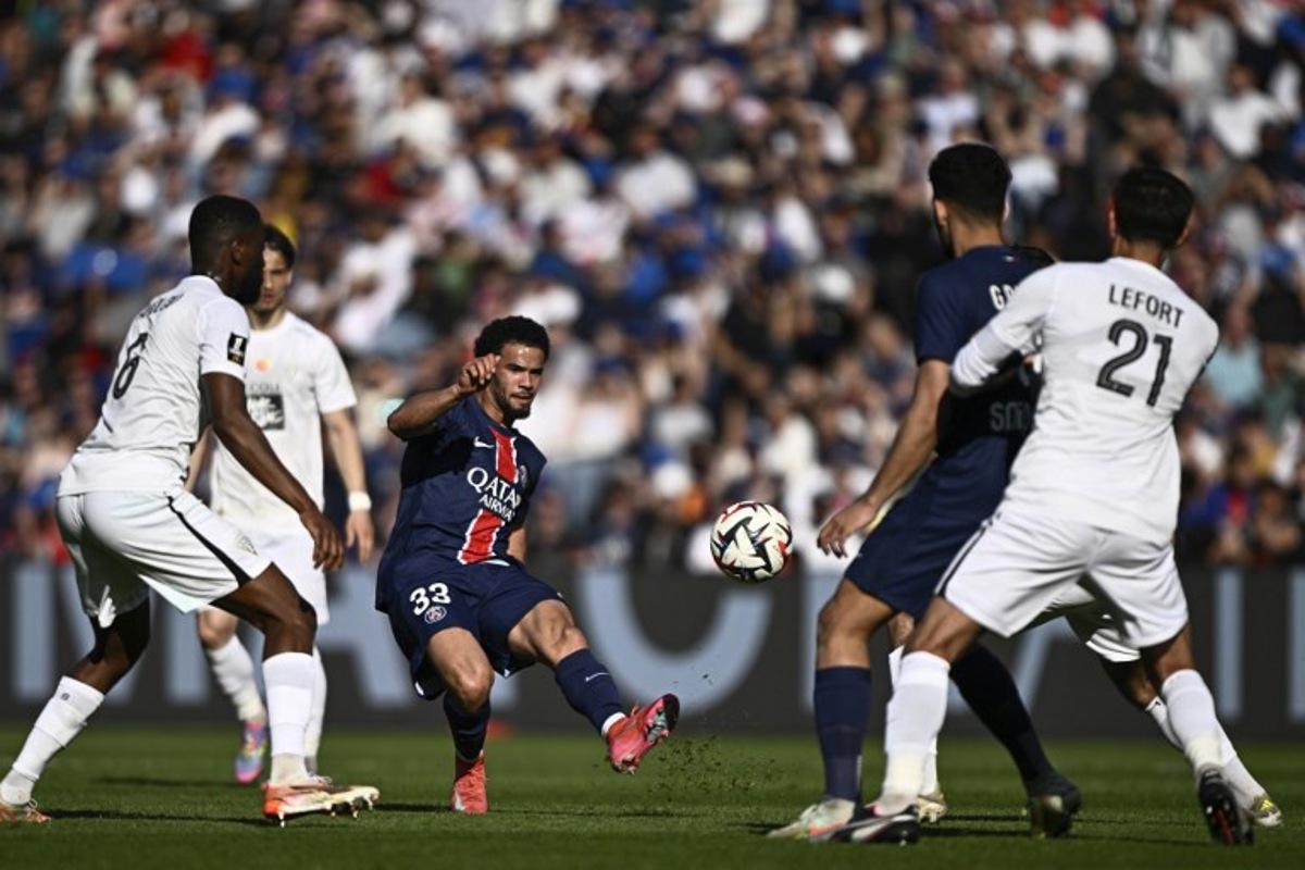 Paris Saint-Germain's French midfielder #33 Warren Zaire-Emery (C) kicks the ball during the French L1 football match between Paris Saint-Germain (PSG) and SCO Angers at The Parc des Princes Stadium in Paris on April 5, 2025.  JULIEN DE ROSA / AFP