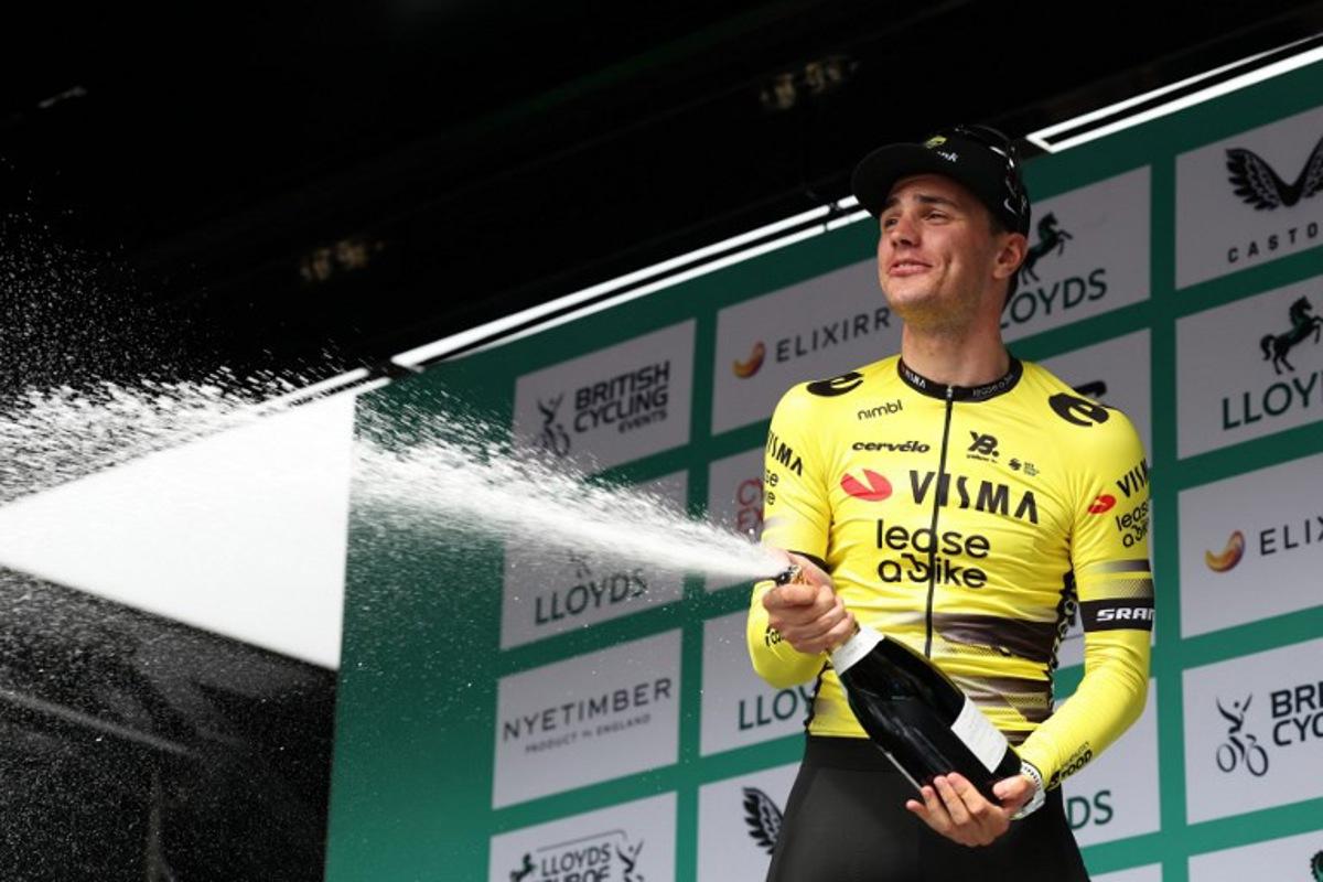 Team Visma Lease a Bike's Dutch rider Olav Kooij sprays the champagne on the podium as he celebrates winning the sixth stage of the Tour of Britain cycling race, in Cardiff on September 7, 2025.  Darren Staples / AFP