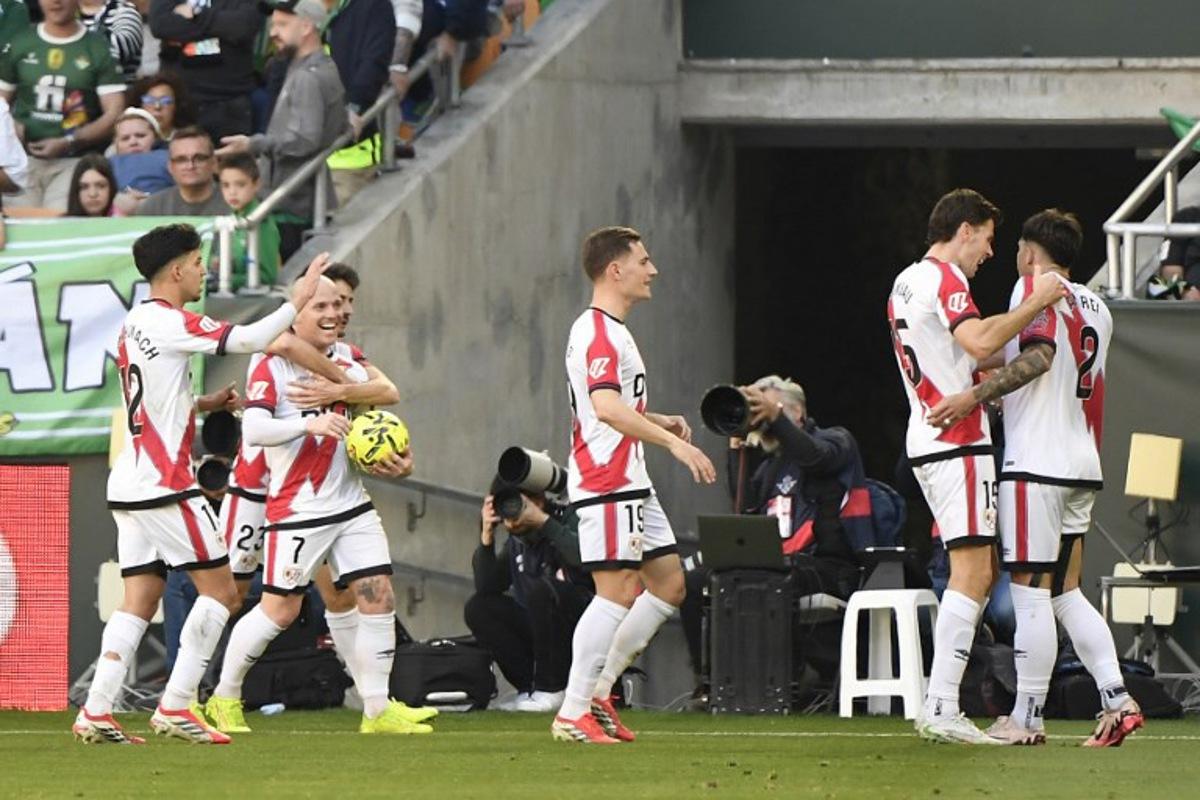 Rayo Vallecano's Spanish forward #07 Isi Palazon celebrates with teammates after scoring an equalizing goal during the Spanish league football match between Real Betis and Rayo Vallecano de Madrid at Benito Villamarin Stadium in Seville on February 21, 2026.  CRISTINA QUICLER / AFP