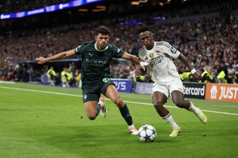 Manchester City's Portuguese midfielder #27 Matheus Nunes (L) vies for the ball with Real Madrid's Brazilian forward #07 Vinicius Junior during the UEFA Champions League league phase day 6 football match between Real Madrid CF and Manchester City at Santiago Bernabeu Stadium in Madrid on December 10, 2025.  Thomas COEX / AFP