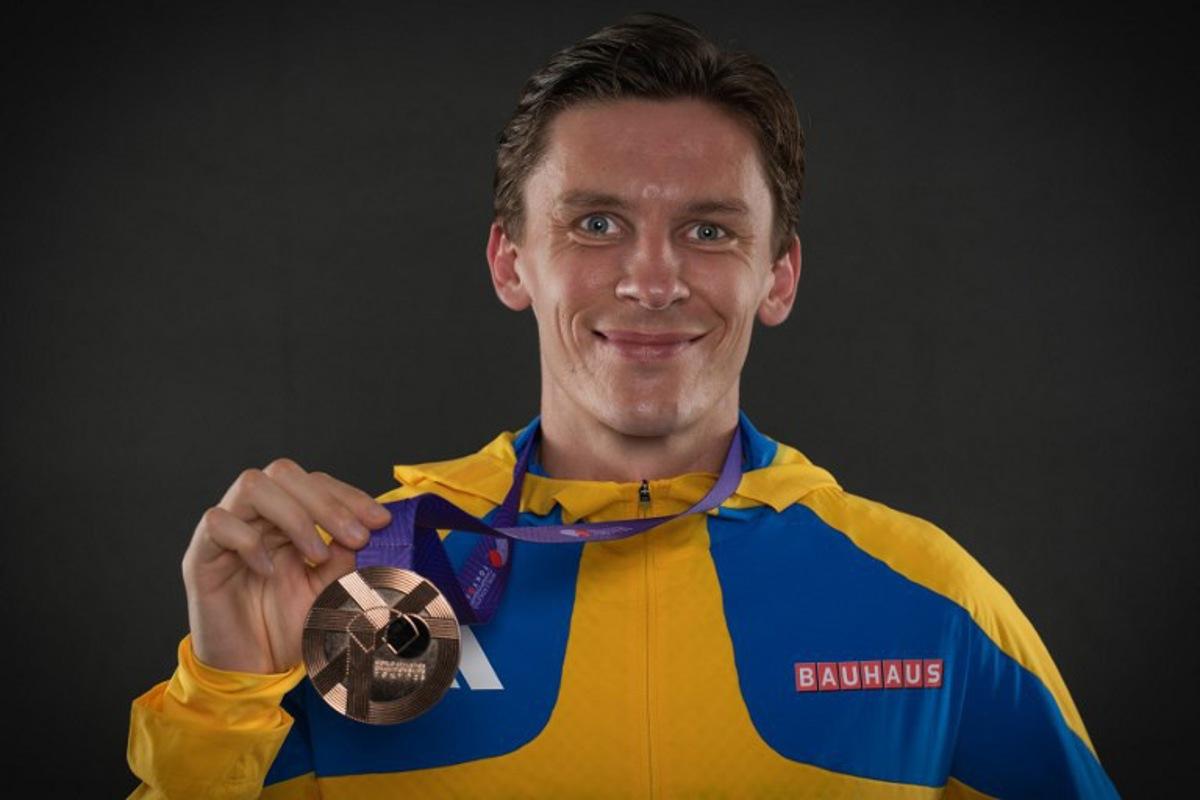 Bronze medallist of the men's 10000m final Sweden's Andreas Almgren poses with his medal for portraits during a studio photo session on the sidelines of the World Athletics Championships in Tokyo on September 15, 2025.  Andrej ISAKOVIC / AFP