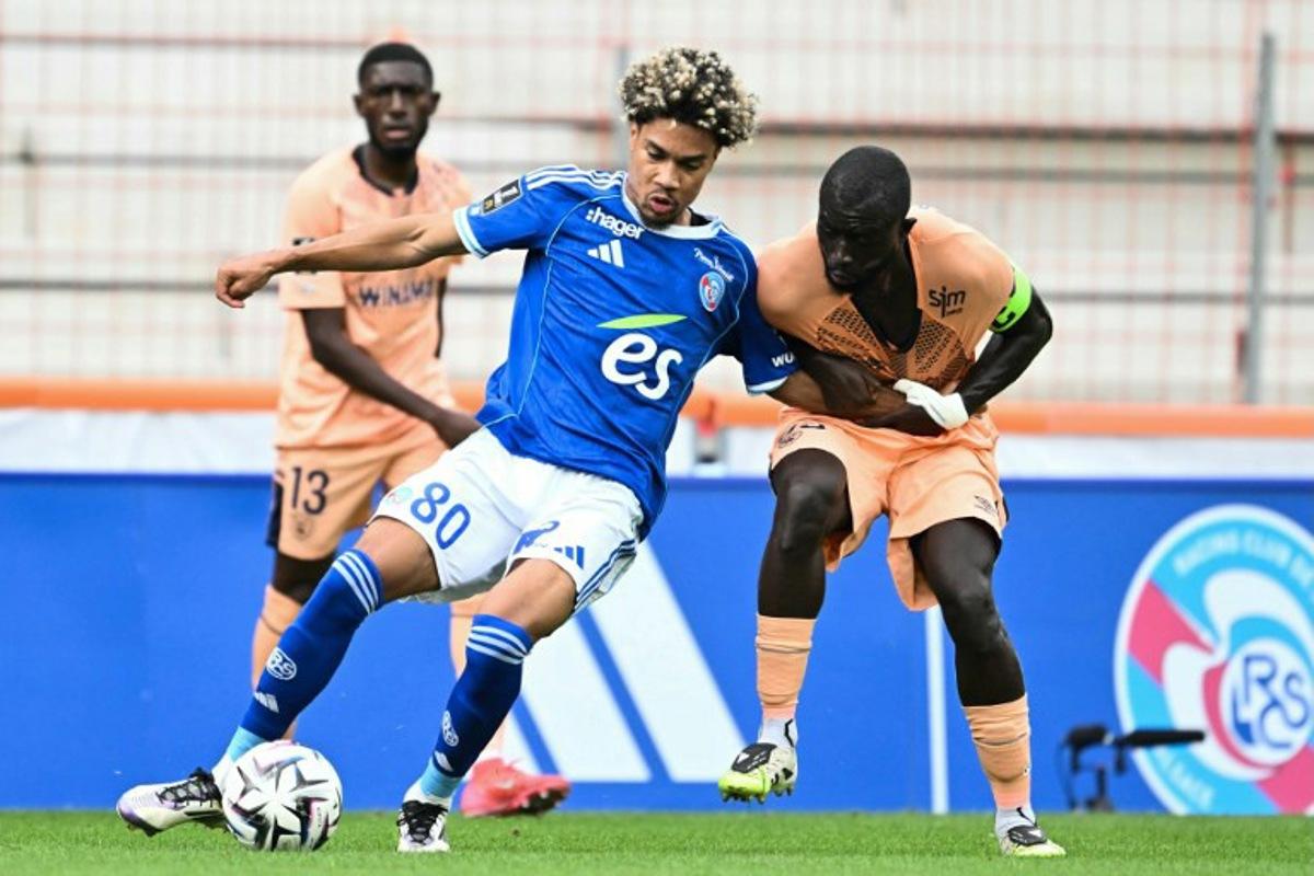 Strasbourg's French midfielder #80 Felix Lemarechal (L) fights for the ball with Le Havre's Senegalese defender #93 Arouna Sangante (R) during the French L1 football match between RC Strasbourg Alsace and Le Havre at the Stade de la Meinau in Strasbourg, eastern France, on September 14, 2025.   SEBASTIEN BOZON / AFP