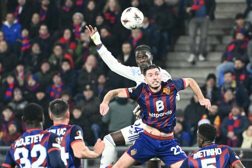Aston Villa's Belgian midfielder #24 Amadou Onana (C) fights to head the ball with Basel's French midfielder #22 Leo Leroy (R) during the UEFA Europa League, league phase, football match between FC Basel and Aston Villa at the St Jakob-Park stadium, in Basel, on December 11, 2025.  SEBASTIEN BOZON / AFP