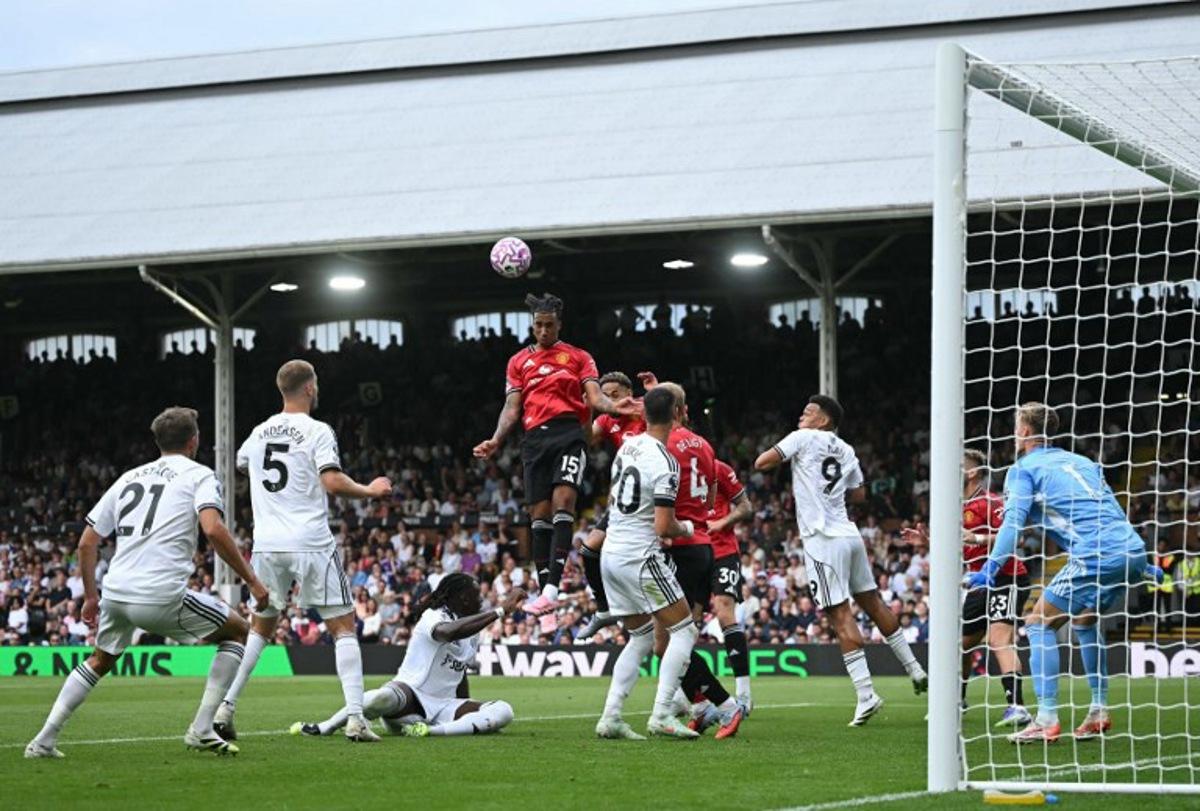 Manchester United's French defender #15 Leny Yoro (C) headers the ball to score the opening goal during the English Premier League football match between Fulham and Manchester United at Craven Cottage in London on August 24, 2025.  JUSTIN TALLIS / AFP