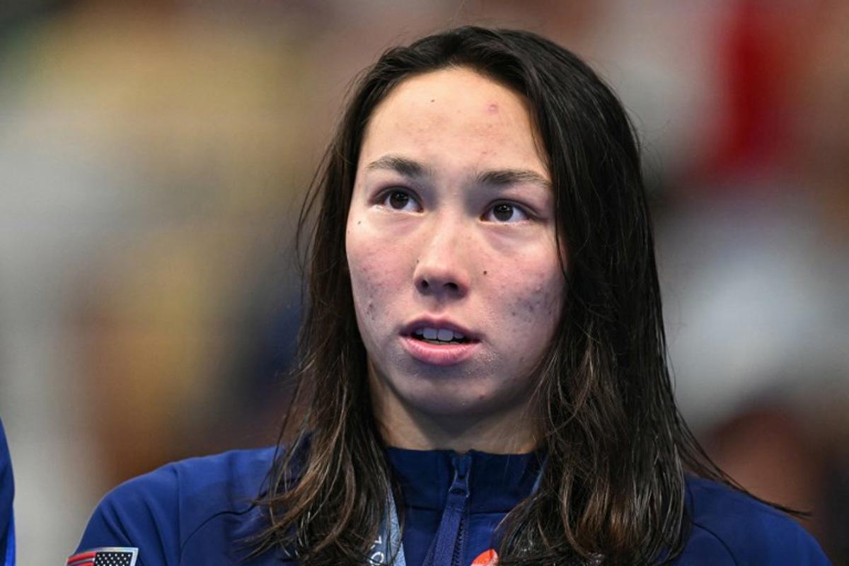 Gold medallist US' Torri Huske stands on the podium after the final of the women's 100m butterfly swimming event during the Paris 2024 Olympic Games at the Paris La Defense Arena in Nanterre, west of Paris, on July 28, 2024.   Manan VATSYAYANA / AFP