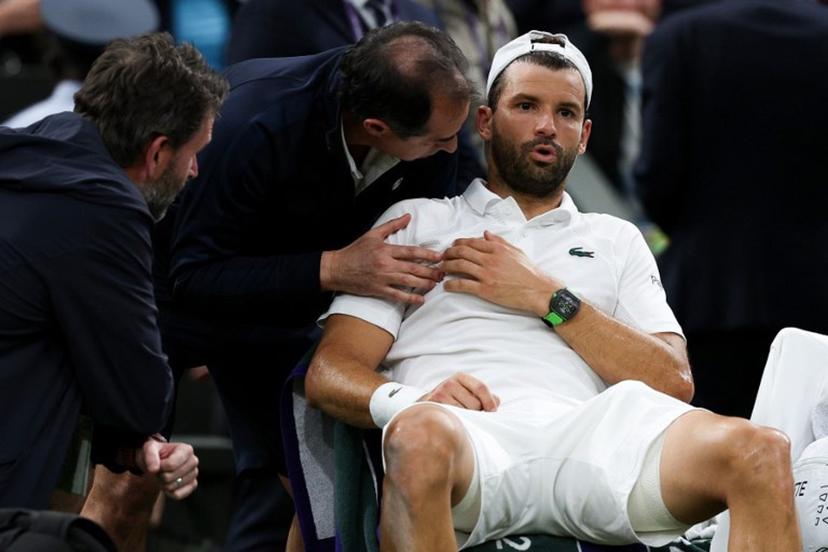 Bulgaria's Grigor Dimitrov reacts as he receives medical treatment after getting injured as he plays against Italy's Jannik Sinner during their men's singles fourth round tennis match on the eighth day of the 2025 Wimbledon Championships at The All England Lawn Tennis and Croquet Club in Wimbledon, southwest London, on July 7, 2025.  Adrian Dennis / AFP
