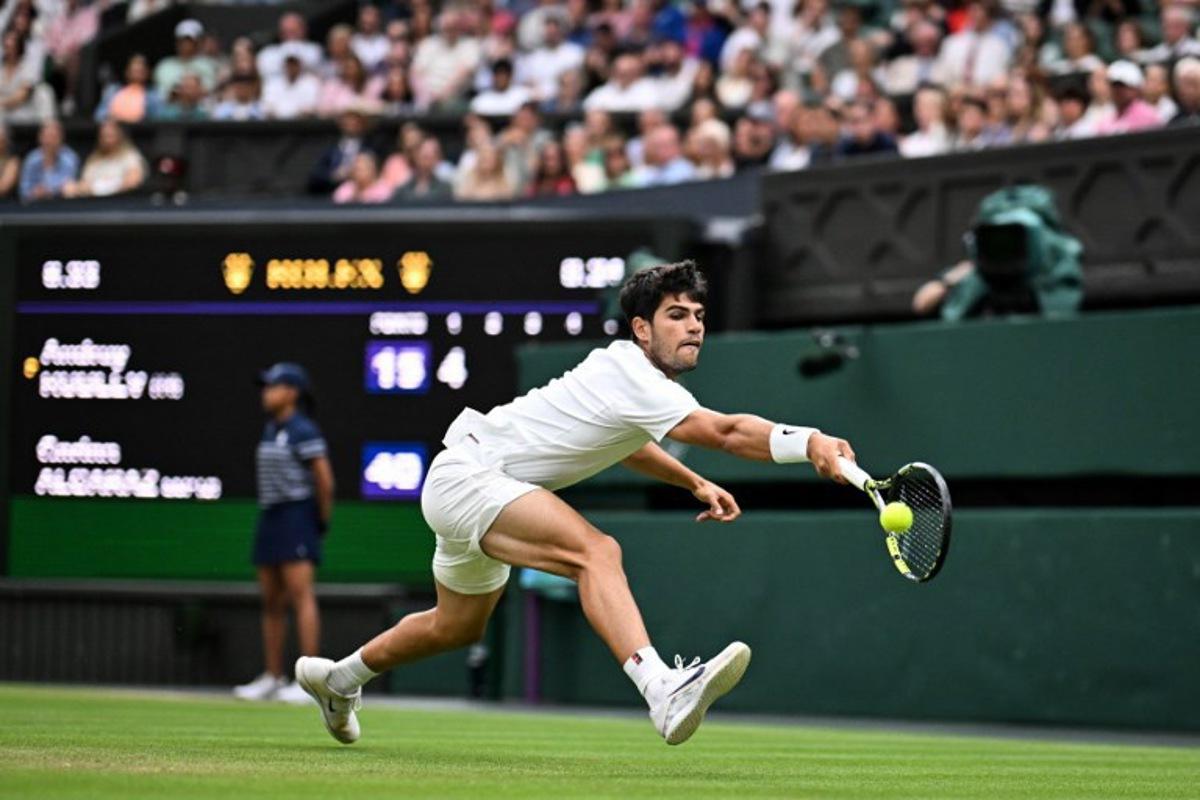 Spain's Carlos Alcaraz plays a backhand return to Russia's Andrey Rublev during their men's singles fourth round tennis match on the seventh day of the 2025 Wimbledon Championships at The All England Lawn Tennis and Croquet Club in Wimbledon, southwest London, on July 6, 2025.  Kirill KUDRYAVTSEV / AFP