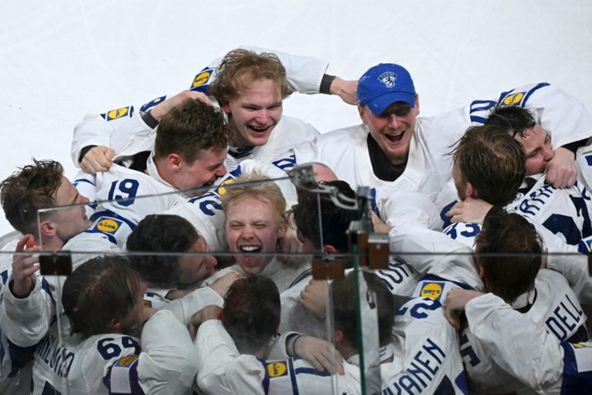 Finland's forward #94 Konsta Helenius (C) celebrates with teammates after scoring the sudden-death goal to win during the over time of the IIHF Ice Hockey Men's World Championship final match between Switzerland and Finland at the Swiss Life Arena in Zurich on May 31, 2026.  SEBASTIEN BOZON / AFP