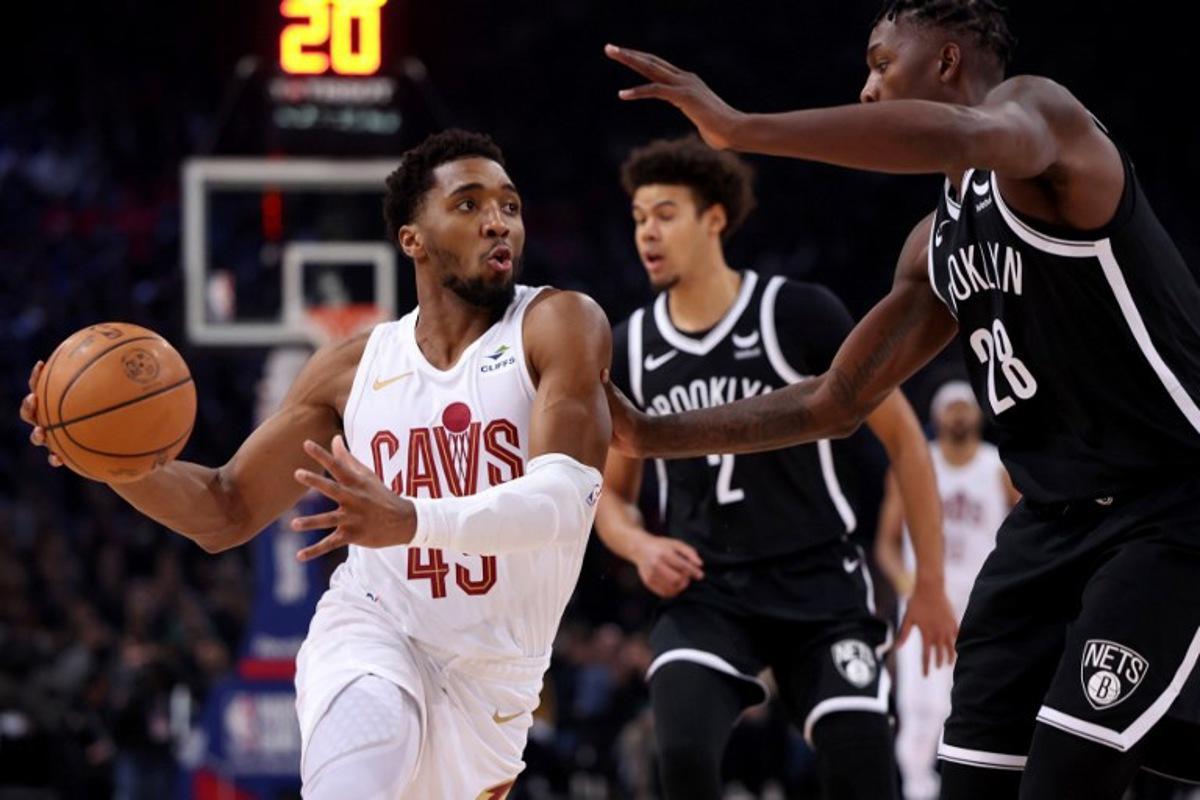 Cleveland Cavaliers' US Point Guard Donovan Mitchell (L) challenges Brooklyn Nets' US Small Forward Dorian Finney-Smith (R) during the NBA regular season basketball match between the Cleveland Cavaliers and the Brooklyn Nets at the Accor Arena in Paris on January 11, 2024.  Emmanuel Dunand / AFP