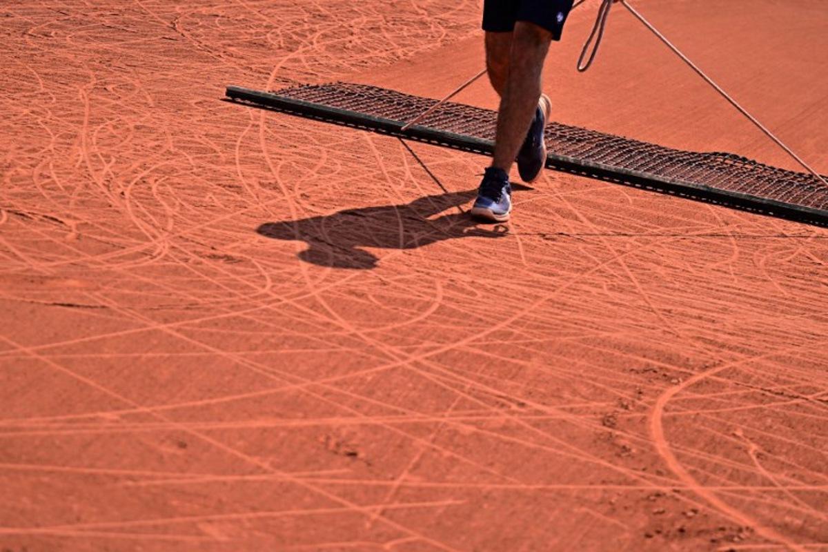 An employee brushes the clay during a wheelchair singles match on day ten of the Roland-Garros Open tennis tournament in Paris on June 6, 2023.  JULIEN DE ROSA / AFP