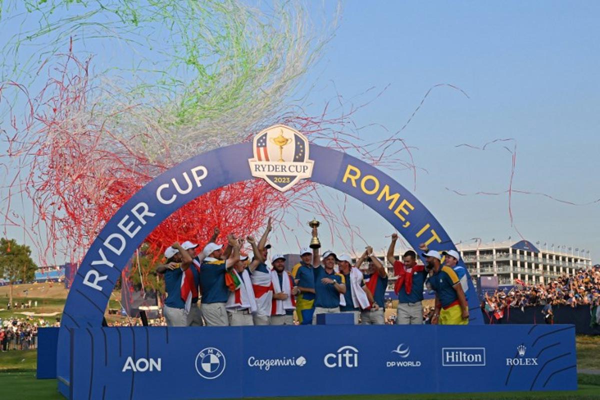 Europe's English captain, Luke Donald lifts the trophy as European players celebrate at the presentation ceremony following the final day of play in the 44th Ryder Cup at the Marco Simone Golf and Country Club in Rome on October 1, 2023.  Tommy Fleetwood clinched the crucial half-point as Europe regained the Ryder Cup from a battling United States on Sunday, taking an unassailable lead despite a blistering American singles charge. Alberto PIZZOLI / AFP