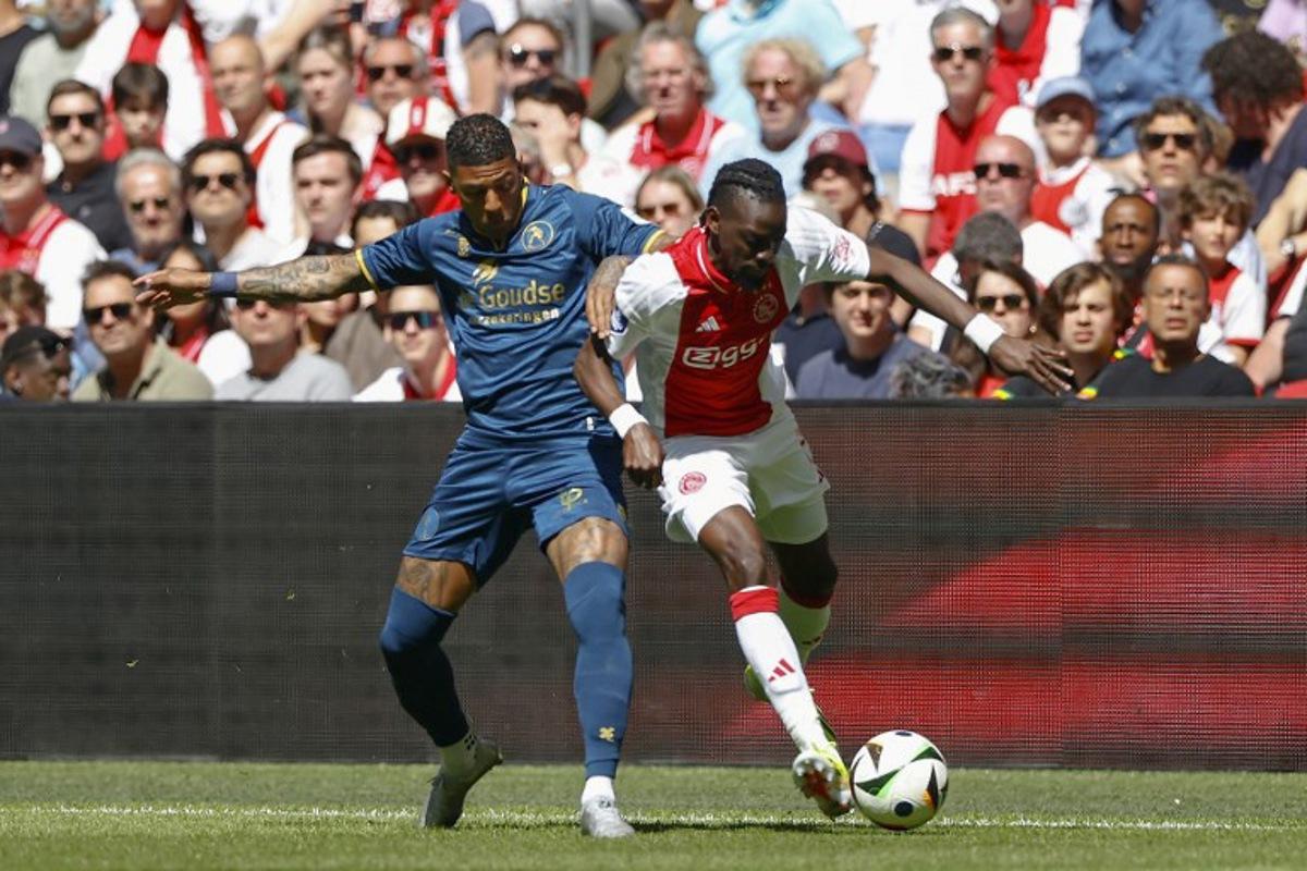 Sparta's Dutch defender #02 Patrick van Aanholt (L) and Ajax's Burkinabe forward #20 Bertrand Traore (R) fight for the ball during the Dutch Eredivisie match between AFC Ajax and Sparta Rotterdam at the Johan Cruijff Arena, in Amsterdam, on April 27, 2025.  MAURICE VAN STEEN / ANP / AFP