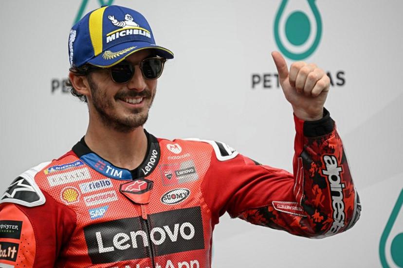 Ducati Lenovo Team's Italian MotoGP rider Francesco Bagnaia (C) celebrates coming first in the qualifying session of the MotoGP Malaysian Grand Prix at the Sepang International Circuit in Sepang on October 25, 2025.  Lillian SUWANRUMPHA / AFP
