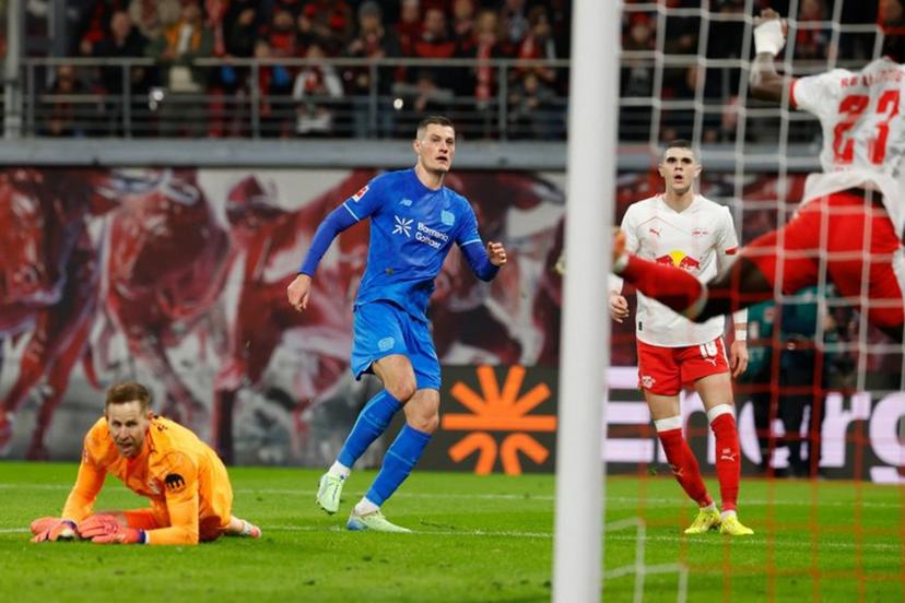Bayer Leverkusen's Czech forward #14 Patrik Schick (C) scores the 1-2 goal past Leipzig's Hungarian goalkeeper #01 Peter Gulacsi (L) during the German first division Bundesliga football match between RB Leipzig and Bayer 04 Leverkusen in Leipzig, eastern Germany, on December 20, 2025.   Odd ANDERSEN / AFP