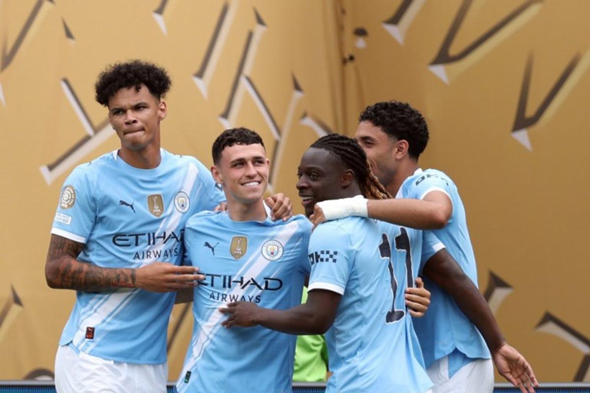 Manchester City's English midfielder #47 Phil Foden (2ndL) is congratulated by teammates after scoring the opening goal during the FIFA Club World Cup 2025 Group G football match between England's Manchester City and Morocco's Wydad AC at the Lincoln Financial Field stadium in Philadelphia on June 18, 2025.  CHARLY TRIBALLEAU / AFP