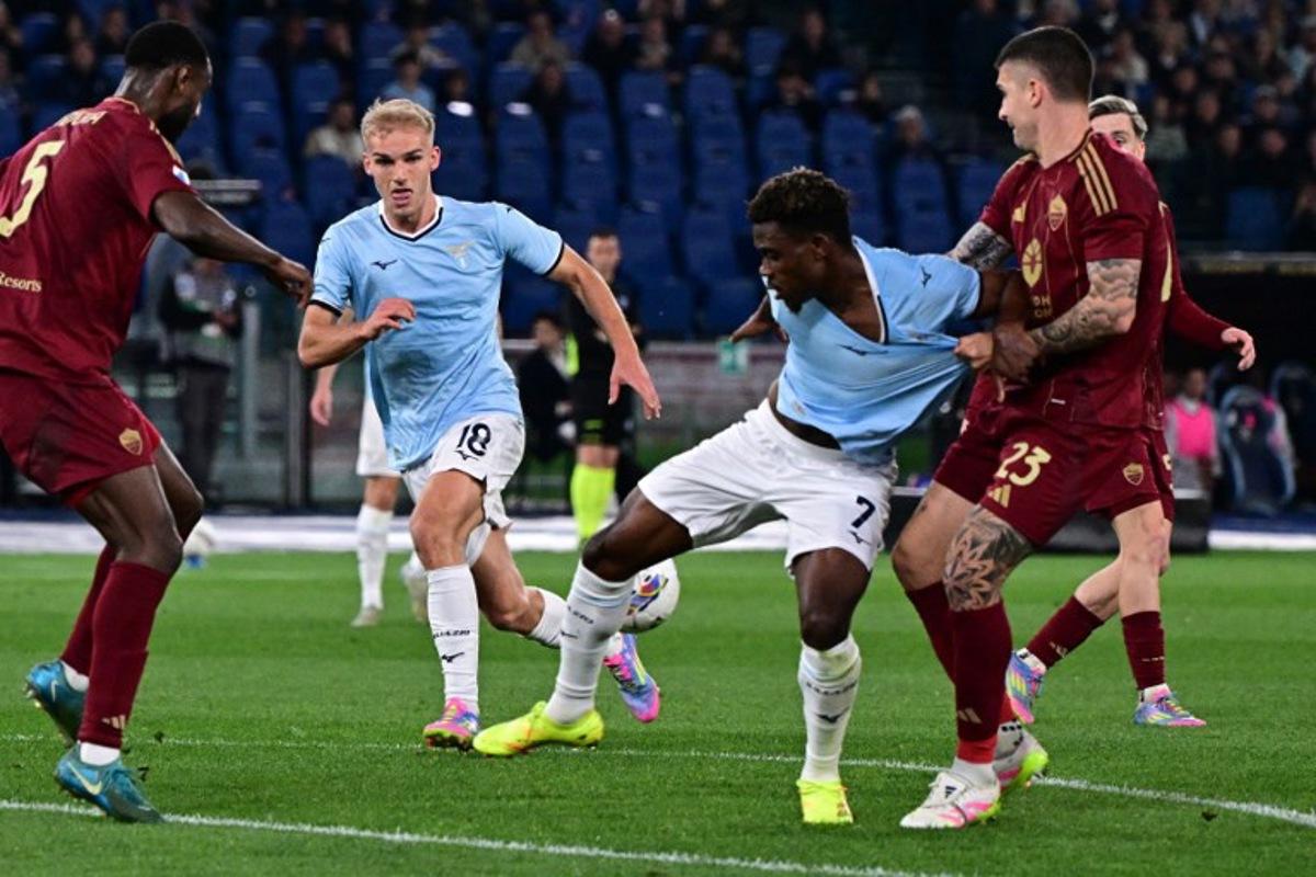 Lazio's Nigerian midfielder #07 Fisayo Dele-Bashiru fights for the ball with Roma's Italian defender #23 Gianluca Mancini during the Italian Serie A football match between Lazio and Roma at the Olympic Stadium in Rome on April 13, 2025.  Tiziana FABI / AFP