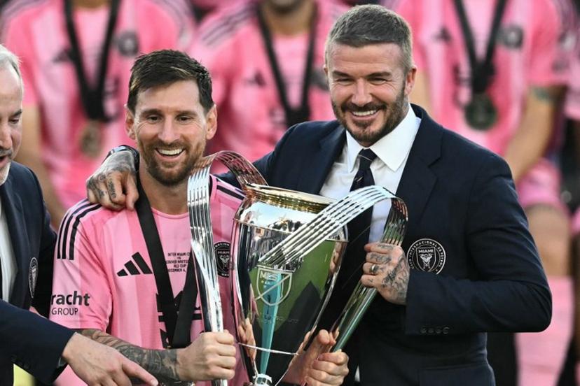 Inter Miami's Argentine forward #10 Lionel Messi (L) poses with the trophy next to the team's owner David Beckham (R) after winning the Major League Soccer (MLS) Cup final between Inter Miami and the Vancouver Whitecaps at Chase Stadium in Fort Lauderdale, Florida, on December 6, 2025.  CHANDAN KHANNA / AFP