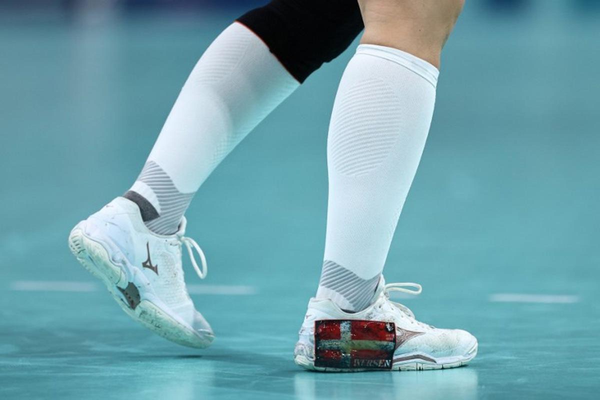 This photogrph shows the Denmak's national flag on the sneaker of Denmark's pivot #05 Sarah Aaberg Iversen during the women's Bronze Medal handball match between Denmark vs Sweden of the Paris 2024 Olympic Games, at the Pierre-Mauroy stadium in Villeneuve-d'Ascq, northern France, on August 10, 2024.  Sameer Al-Doumy / AFP