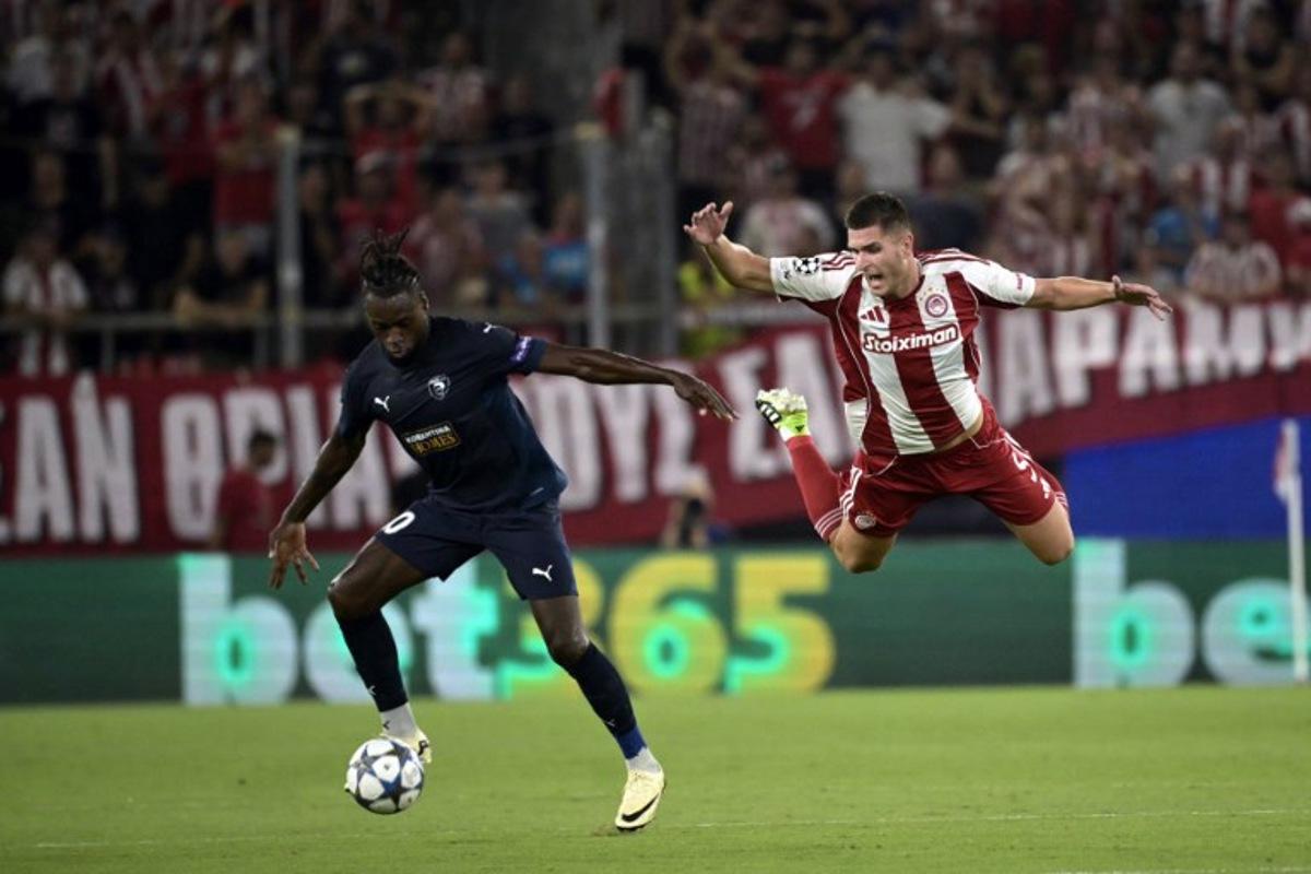 Olympiakos' Italian defender #05 Lorenzo Pirola (R) and Pafos FC's Belgian forward #10 Landry Dimata fight for the ball during the UEFA Champions League football league stage match between Olympiakos and Pafos at the Karaiskakis stadium in Piraeus on September 17, 2025.   Angelos Tzortzinis / AFP