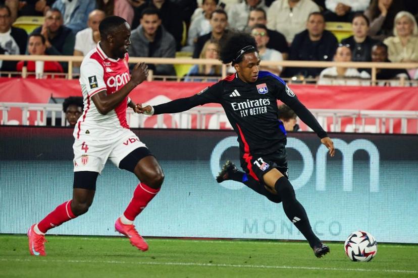 Lyon's Belgian forward #11 Malick Fofana (R) kicks the ball next to Monaco's Dutch defender #04 Jordan Teze during the French L1 football match between AS Monaco and Olympique Lyonnais (OL) at the Louis II Stadium (Stade Louis II) in the Principality of Monaco on May 10, 2025.  CLEMENT MAHOUDEAU / AFP