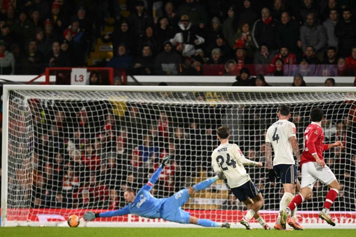 Wrexham's New Zealand defender #13 Liberato Cacace (R) scores the opening goal past Nottingham Forest's Belgian goalkeeper #26 Matz Sels during the English FA Cup third round football match between Wrexham and Nottingham Forest at the Racecourse Ground Stadium in Wrexham, north Wales, on January 9, 2026.  Oli SCARFF / AFP