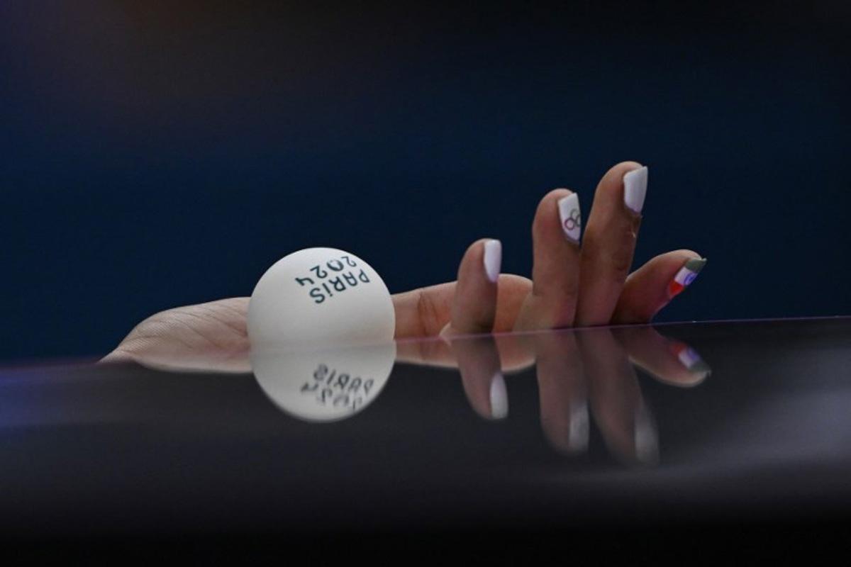 A detailed view of India's Manika Batra's nails painted with the Indian flag and Olympic Rings as she prepares to serve the ball during her women's table tennis singles match in the team quarter-finals between India and Germany at the Paris 2024 Olympic Games at the South Paris Arena in Paris on August 7, 2024.  WANG Zhao / AFP