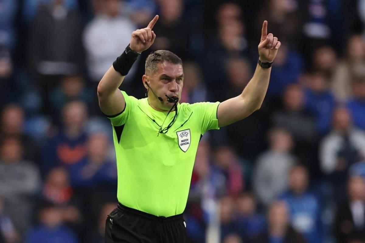 Romanian referee Istvan Kovacs gestures during the UEFA Europa League quarter final football match between Rangers and Athletic Club Bilbao at the Ibrox Stadium in Glasgow on April 10, 2025.  Ewan Bootman / AFP