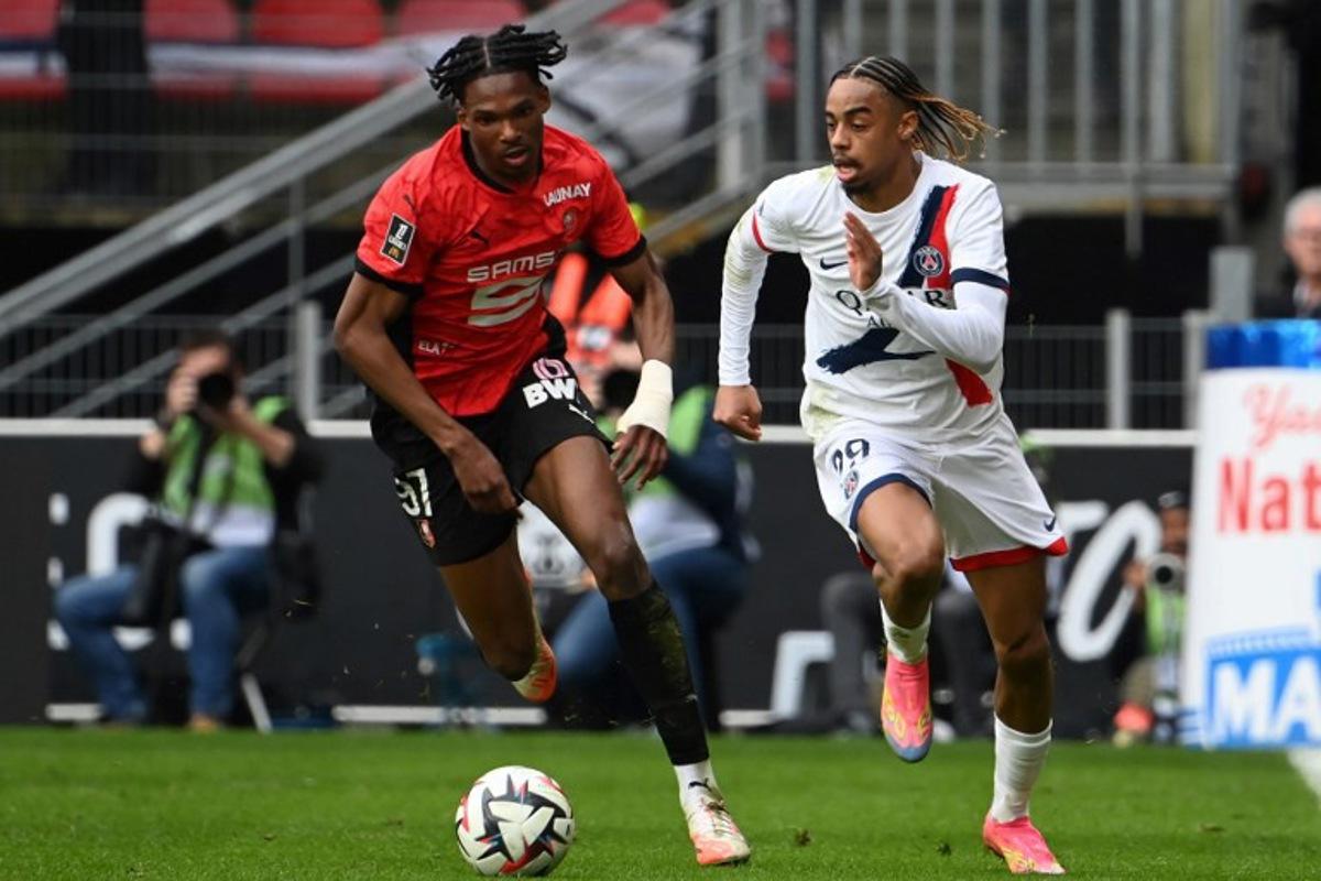 Rennes french defemder  #97 Jeremy Jacquet and Paris Saint-Germain's French forward #29 Bradley Barcola  fight for the ball during the French L1 football match between Stade Rennais FC and Paris Saint-Germain (PSG) at Roazhon Park Stadium in Rennes, western France on March 8, 2025.  JEAN-FRANCOIS MONIER / AFP