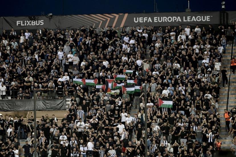 PAOK fans hold Palestinian flags during the UEFA Europa League football match day 1, between PAOK Salonika and Maccabi Tel-Aviv at the Toumba Stadium, in Thessaloniki on September 24, 2025.  SAKIS MITROLIDIS / AFP