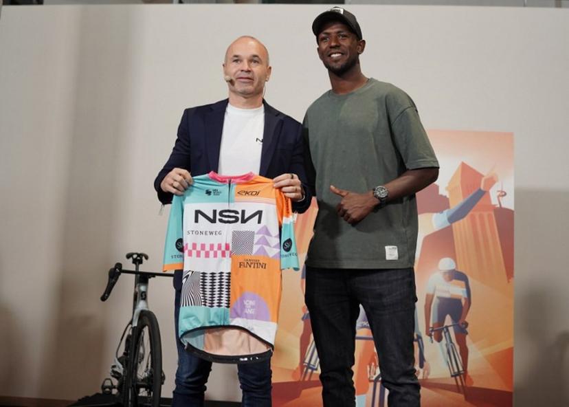 NSN co-founder former Spain and Barcelona football star Andres Iniesta and Erythrean cyclist Binian Girmay (R) attend the official presentation of the NSN cycling team - ex Israel-Premier Tech - in Barcelona on December 9, 2025. Iniesta is a co-founder of sports and entertainment agency NSN, which partnered with Swiss global investment platform Stoneweg, took over Israel-Premier Tech team in November. IPT's presence at the Vuelta a Espana this year was heavily protested by pro-Palestinian supporters, with several stages of the race heavily disrupted. Manaure Quintero / AFP