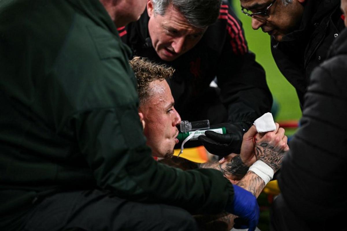 Galatasaray's Dutch forward #77 Noa Lang receives medical attention after cutting his thumb during the UEFA Champions League, round of 16 second leg football match between Liverpool and Galatasaray at Anfield in Liverpool, north-west England on March 18, 2026.  Paul ELLIS / AFP