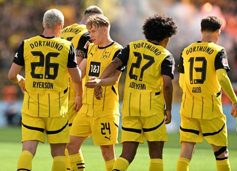 Dortmund's Norwegian defender #26 Julian Ryerson (L) celebrates his 1-2 with teammates during the German first division Bundesliga football match between Bayer 04 Leverkusen and Borussia Dortmund in Leverkusen, western Germany, on May 11, 2025.  INA FASSBENDER / AFP