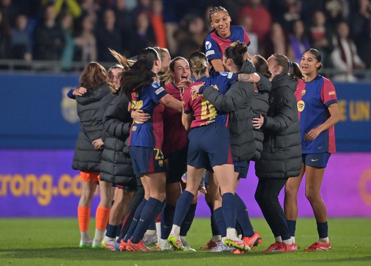 Barcelona players celebrate their victory afterrafa the UEFA Women's Champions League quarter-final second-leg football match between FC Barcelona and VfL Wolfsburg at the Estadi Johan Cruyff in Barcelona, on March 27, 2025.  Manaure QUINTERO / AFP