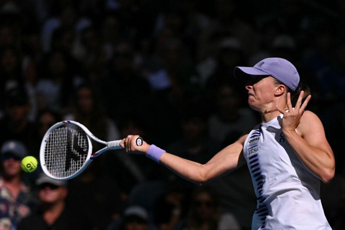 Poland's Iga Swiatek hits a return to Czech Republic's Marie Bouzkova during their women's singles match on day five of the Australian Open tennis tournament in Melbourne on January 22, 2026.  WILLIAM WEST / AFP